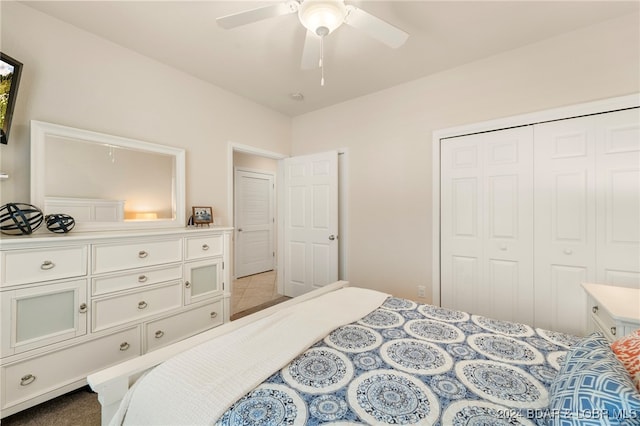 carpeted bedroom with ceiling fan and a closet