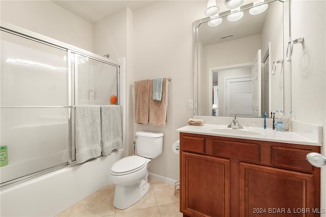 full bathroom with tile patterned floors, shower / bath combination with glass door, vanity, and toilet