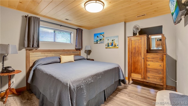 bedroom with crown molding, light hardwood / wood-style floors, and wooden ceiling