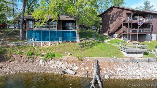 exterior space featuring a yard and a deck with water view