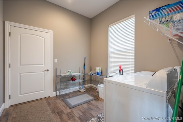 clothes washing area with independent washer and dryer and hardwood / wood-style flooring