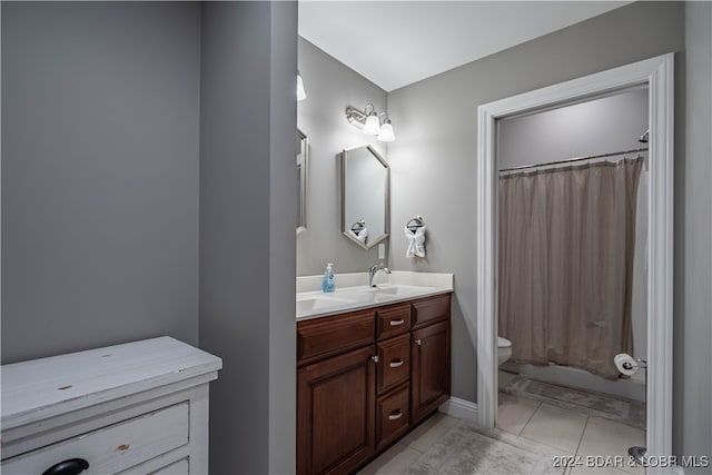 full bathroom with vanity, shower / bath combo with shower curtain, toilet, and tile patterned floors