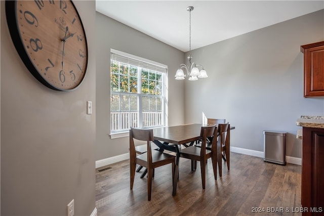 dining area with a notable chandelier and dark hardwood / wood-style floors