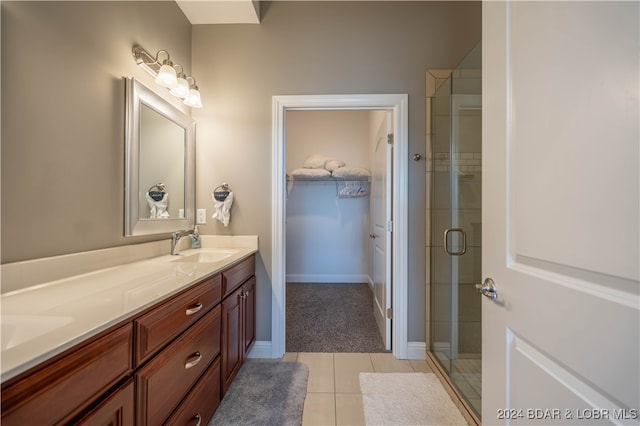 bathroom featuring vanity, walk in shower, and tile patterned flooring