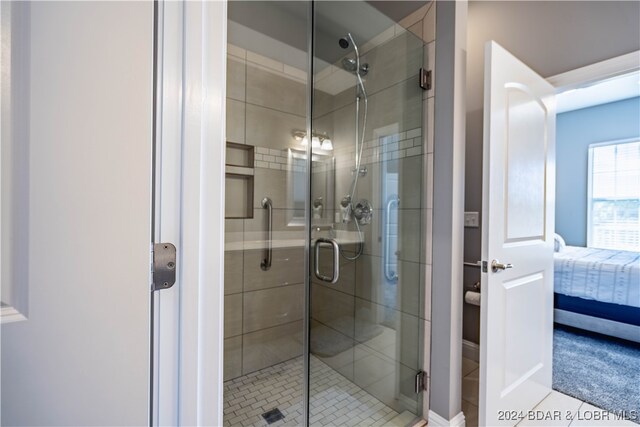 bathroom with an enclosed shower and tile patterned flooring