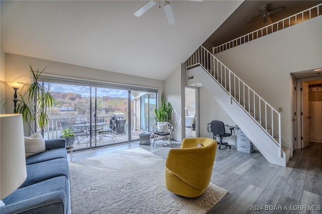 living room with ceiling fan, high vaulted ceiling, wood-type flooring, and a mountain view