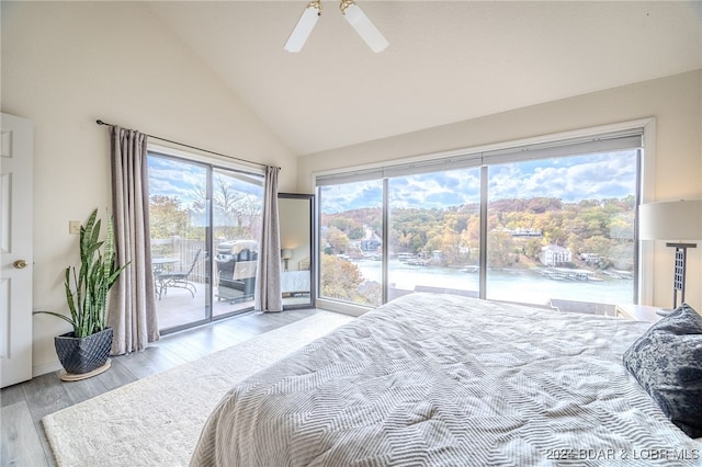 bedroom with ceiling fan, access to outside, high vaulted ceiling, light wood-type flooring, and a water view