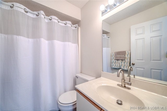 bathroom with vanity, toilet, a textured ceiling, and curtained shower