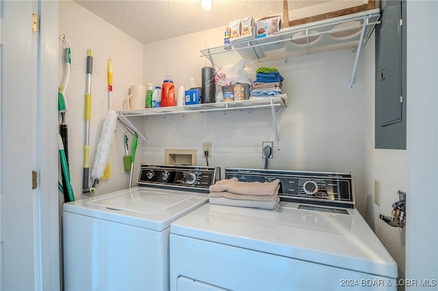 clothes washing area with electric panel, independent washer and dryer, and a textured ceiling