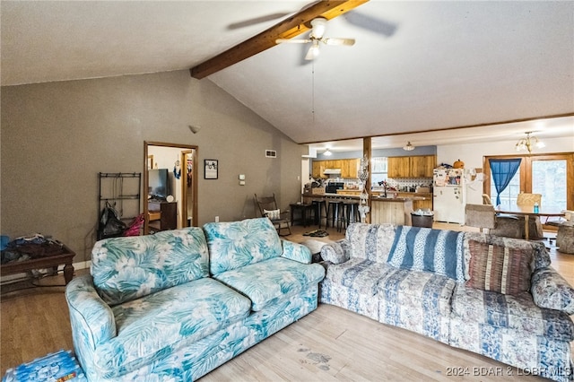 living room featuring lofted ceiling with beams, light hardwood / wood-style flooring, and ceiling fan with notable chandelier