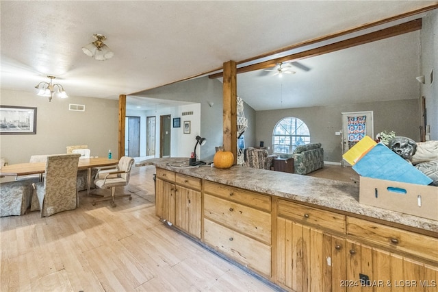 kitchen featuring lofted ceiling, ceiling fan with notable chandelier, and light wood-type flooring