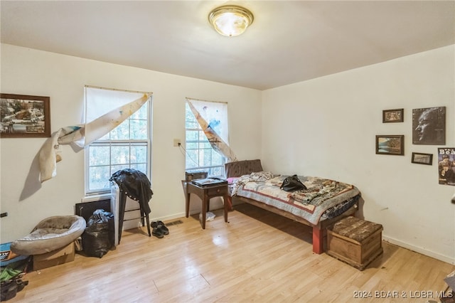 bedroom with light hardwood / wood-style flooring and multiple windows