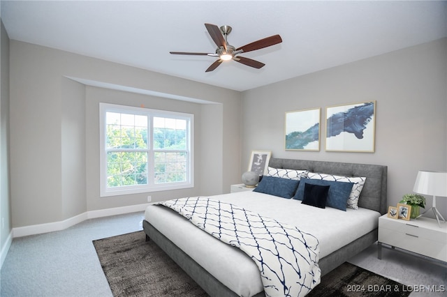 carpeted bedroom with a ceiling fan and baseboards