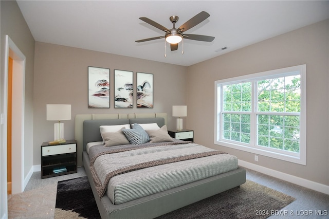 carpeted bedroom featuring a ceiling fan, visible vents, and baseboards