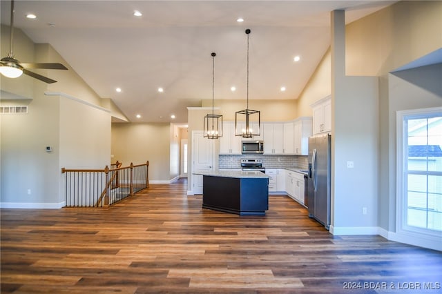 kitchen featuring appliances with stainless steel finishes, pendant lighting, high vaulted ceiling, white cabinets, and a kitchen island