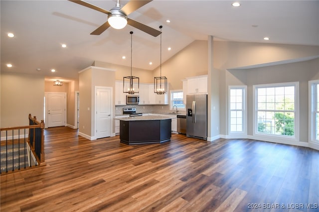 kitchen featuring stainless steel appliances, decorative light fixtures, white cabinetry, dark hardwood / wood-style floors, and a kitchen island