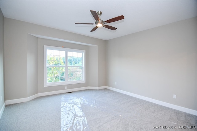 unfurnished room featuring light carpet and ceiling fan