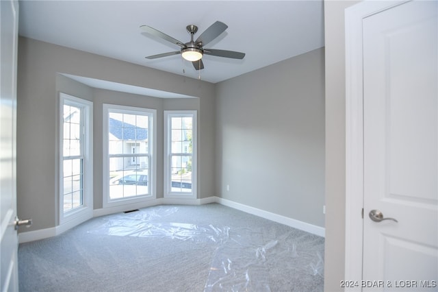 unfurnished room with ceiling fan and light carpet