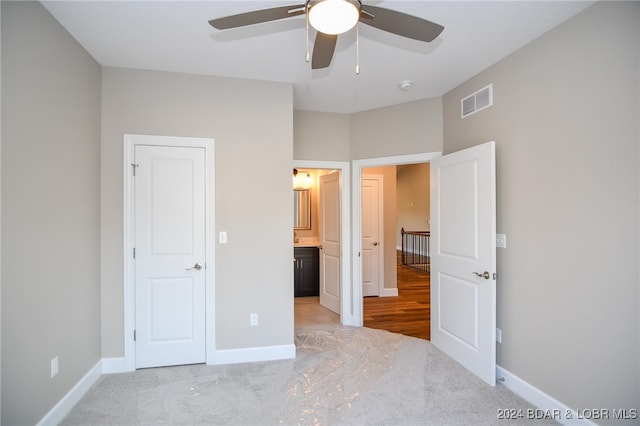 unfurnished bedroom with ensuite bath and ceiling fan