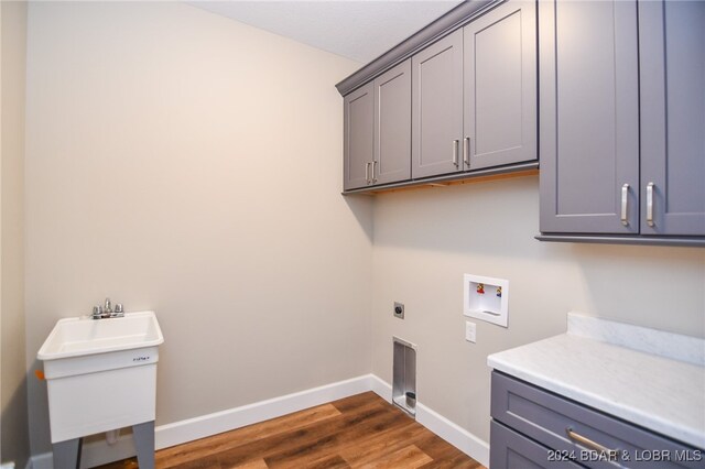 laundry room with cabinets, hookup for a washing machine, dark hardwood / wood-style floors, and electric dryer hookup