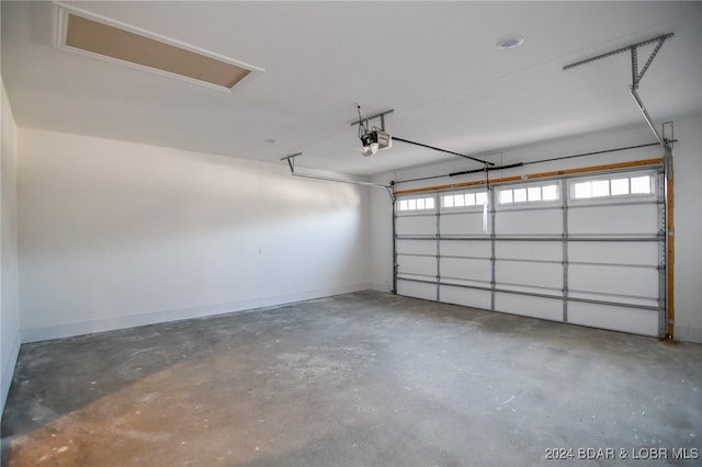 garage with baseboards and a garage door opener