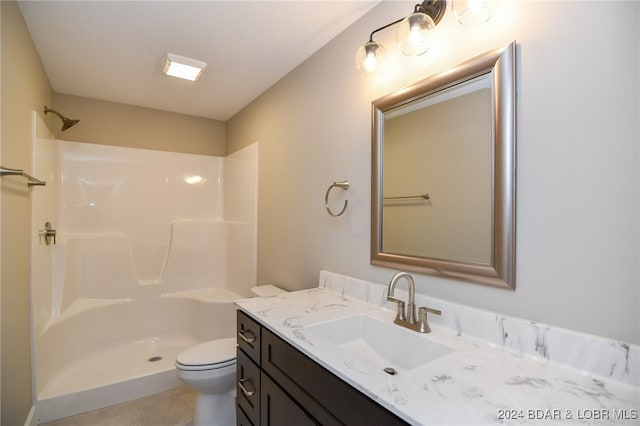 bathroom featuring walk in shower, tile patterned floors, vanity, and toilet