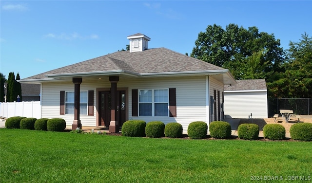 bungalow featuring a front lawn, roof with shingles, and fence