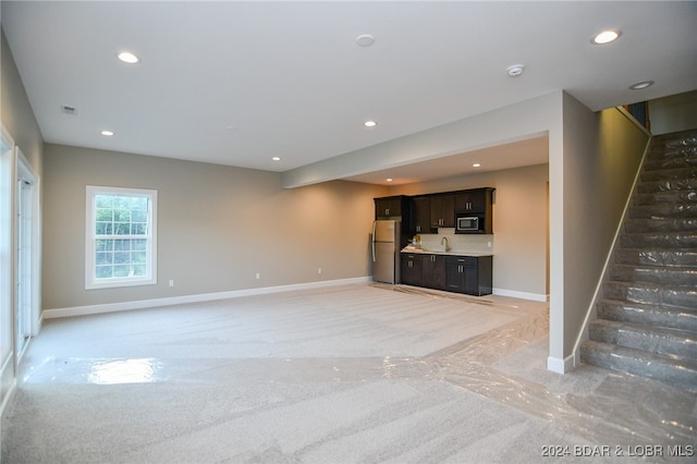 unfurnished living room featuring light colored carpet