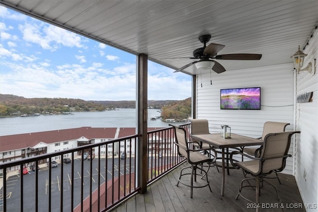 wooden terrace featuring a water view and ceiling fan