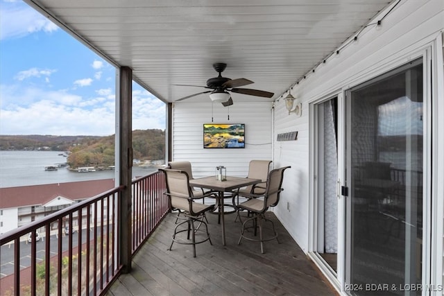 sunroom featuring a water view and ceiling fan