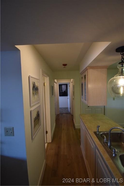 hallway featuring sink and dark wood-type flooring