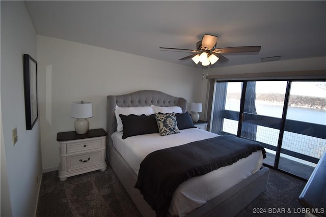 carpeted bedroom with a water view, access to exterior, and ceiling fan