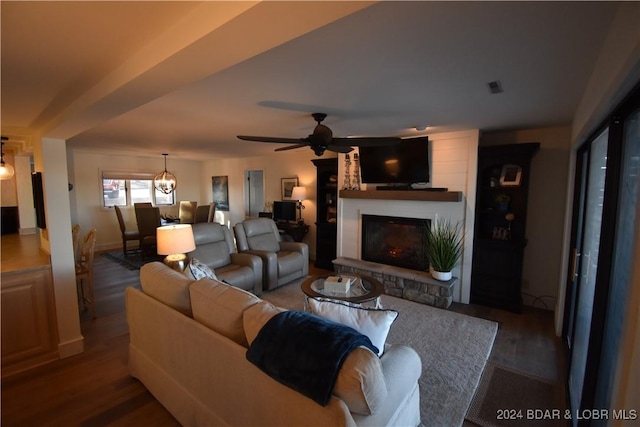 living room with dark wood-type flooring, ceiling fan, and a fireplace