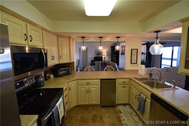 kitchen featuring appliances with stainless steel finishes, kitchen peninsula, sink, and hanging light fixtures