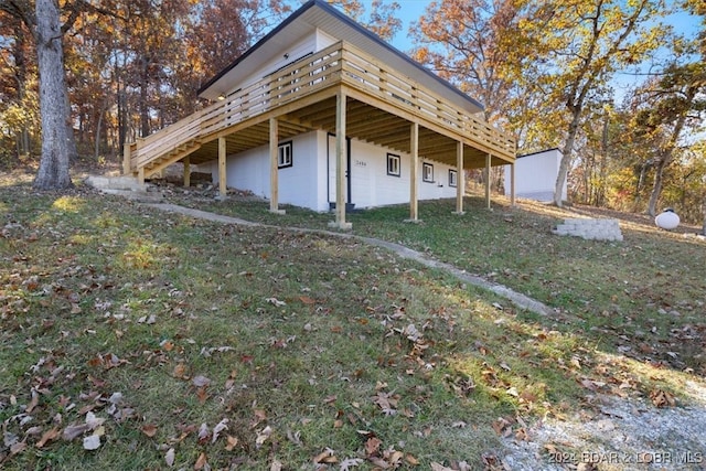 view of property exterior featuring a wooden deck and a yard