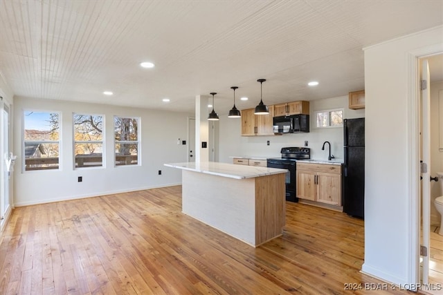 kitchen featuring light hardwood / wood-style flooring, black appliances, a center island, and hanging light fixtures