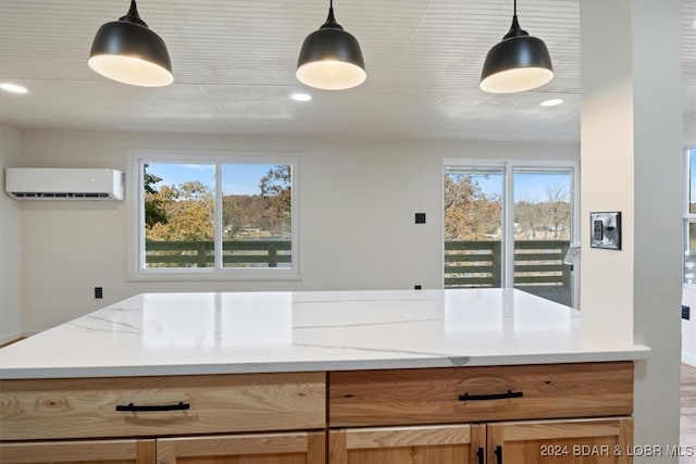 kitchen featuring pendant lighting, light stone counters, hardwood / wood-style flooring, and a wall mounted air conditioner