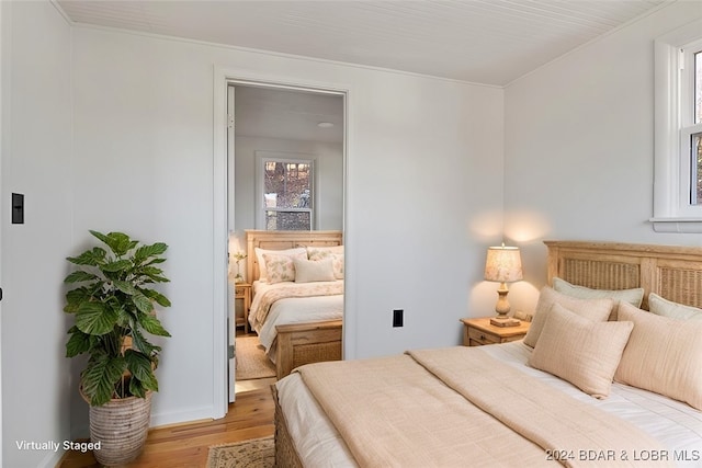 bedroom with multiple windows and light hardwood / wood-style floors