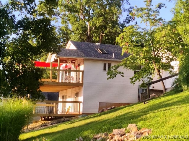 rear view of house with a lawn and a deck