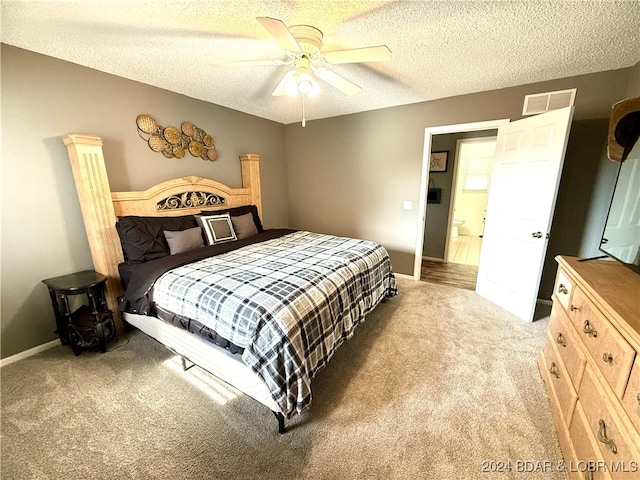 carpeted bedroom featuring ceiling fan and a textured ceiling