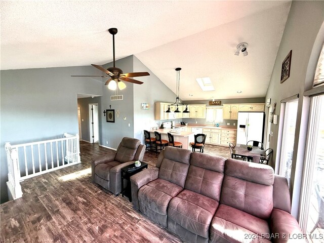 living room with a textured ceiling, hardwood / wood-style flooring, high vaulted ceiling, and ceiling fan