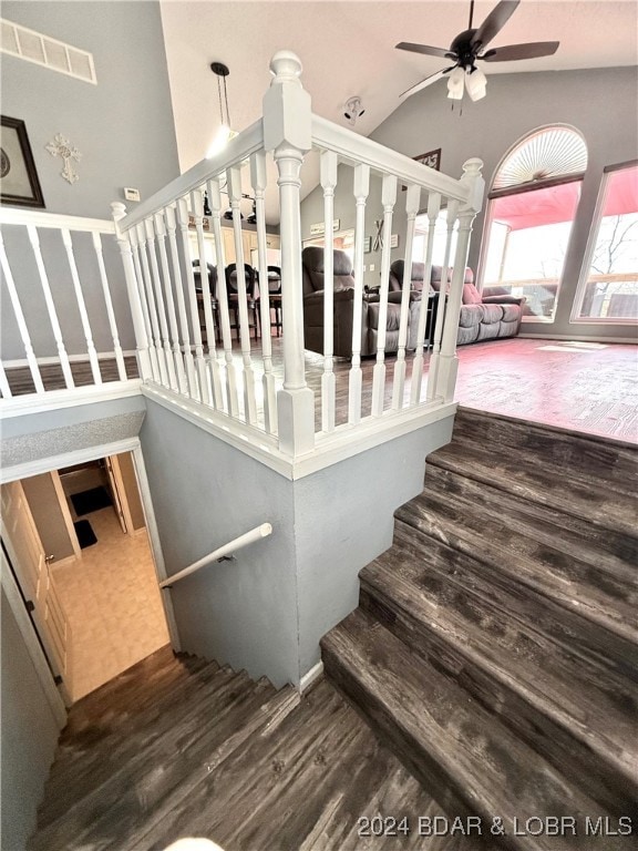 staircase featuring wood-type flooring, high vaulted ceiling, and ceiling fan