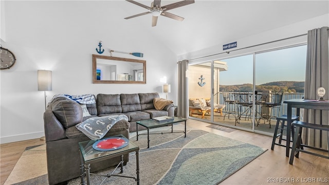 living room with a mountain view, hardwood / wood-style flooring, high vaulted ceiling, and ceiling fan