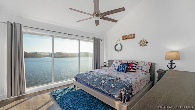 bedroom with hardwood / wood-style flooring, lofted ceiling, access to exterior, a water view, and ceiling fan