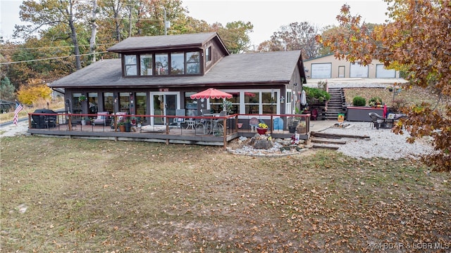 rear view of house featuring a deck and a yard