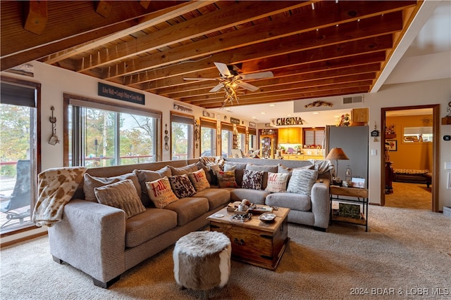 carpeted living room featuring ceiling fan and beamed ceiling