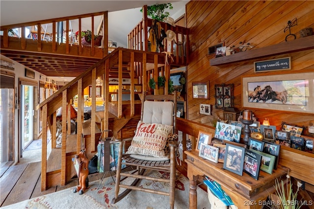 sitting room featuring hardwood / wood-style floors and wooden walls