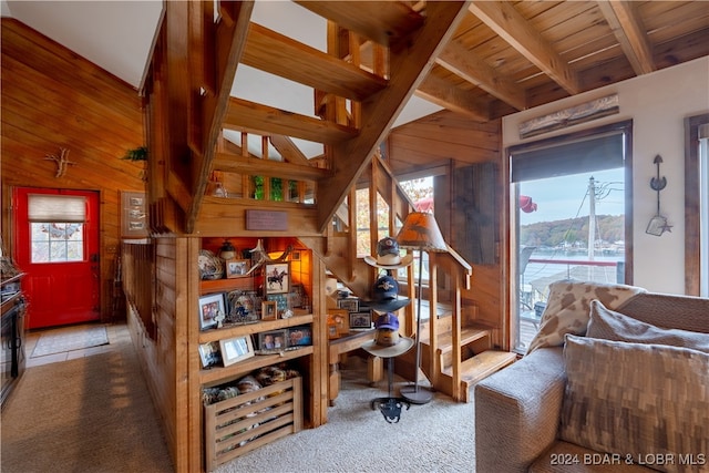 carpeted home office featuring beam ceiling, wooden ceiling, and wooden walls