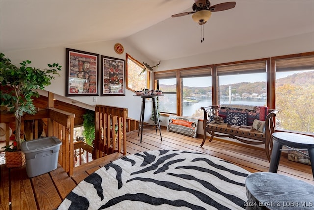 sunroom / solarium with lofted ceiling, a water view, and ceiling fan