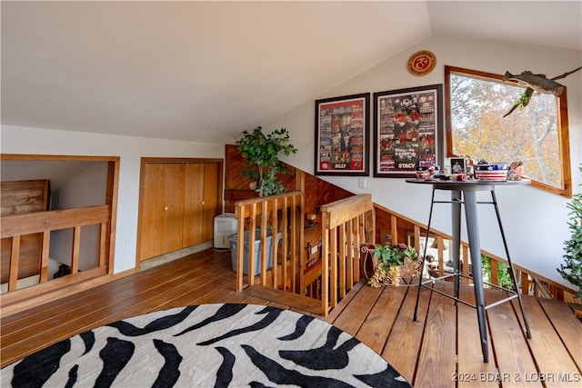 stairway featuring hardwood / wood-style floors and vaulted ceiling